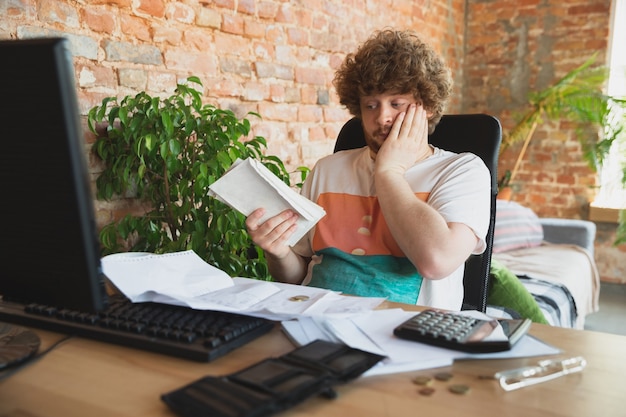 A person looking stressed and overwhelmed at a desk covered in tax documents, highlighting the feeling of confusion and the need for clarity when claiming tax credits.