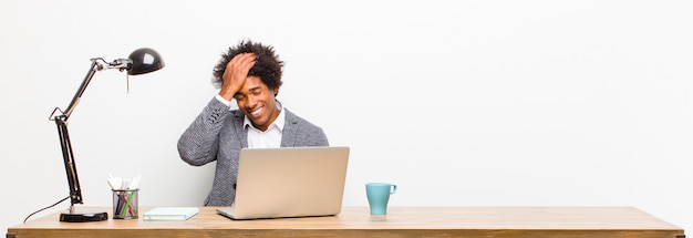 A person sitting at a desk looking stressed, with hands on their head. In the background, there's a subtle graphic of a helping hand, symbolizing support and problem-solving. The image should look somewhat desaturated to enhance the feeling of stress.
