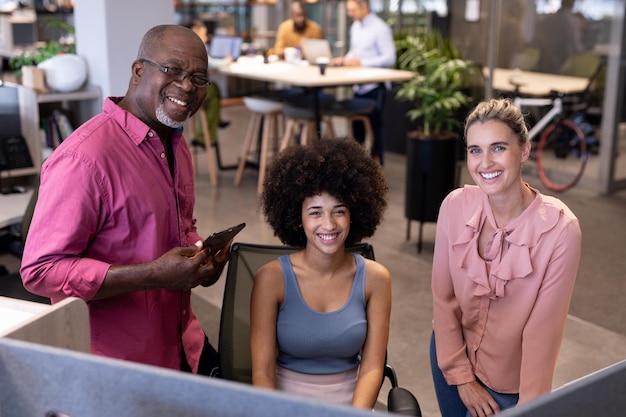 A group of diverse professionals in a modern office setting, smiling and collaborating around a table, with charts and graphs visible in the background. The image represents the business side of employer-sponsored life insurance and its implications.