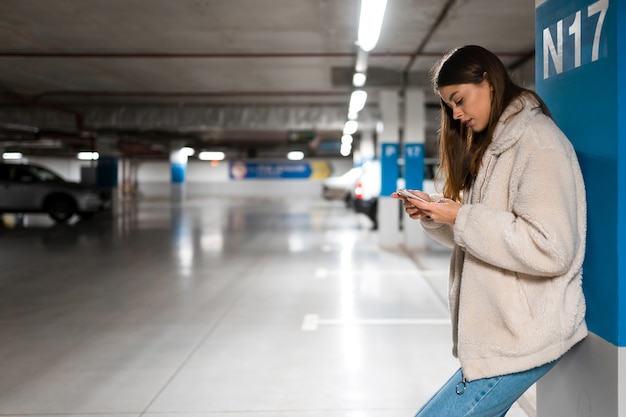A person scanning a parking ticket at a parking garage exit, with a focus on the card reader and the visible company logo in the background, representing how commuter benefits can be used for parking expenses.