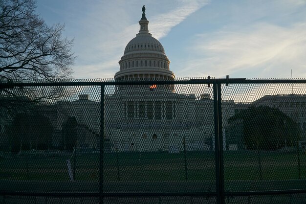 A close-up shot of a gavel hitting a sound block with a blurred image of the US Capitol Building in the background.