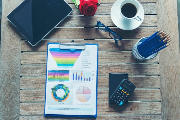 A detailed financial report with charts and graphs showing income, expenses, and investment growth. Pens and a calculator are placed beside the report, signifying careful financial planning and analysis. The image is well-lit and professional-looking.