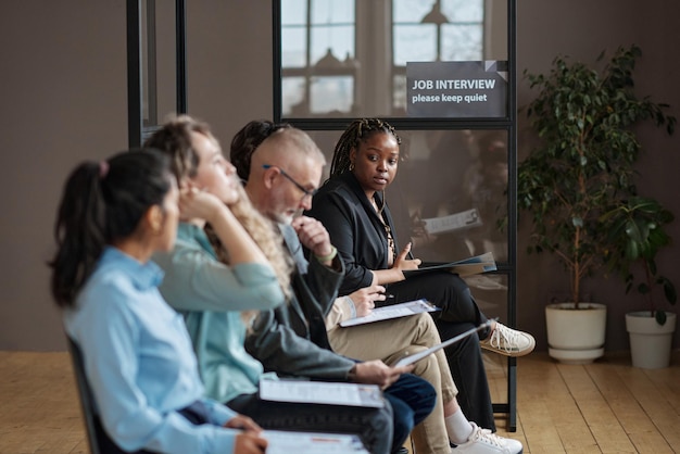 A diverse group of adults attending a financial planning seminar, focused on a presentation about retirement and career transitions. The room is brightly lit, and participants are taking notes and engaging with the speaker.