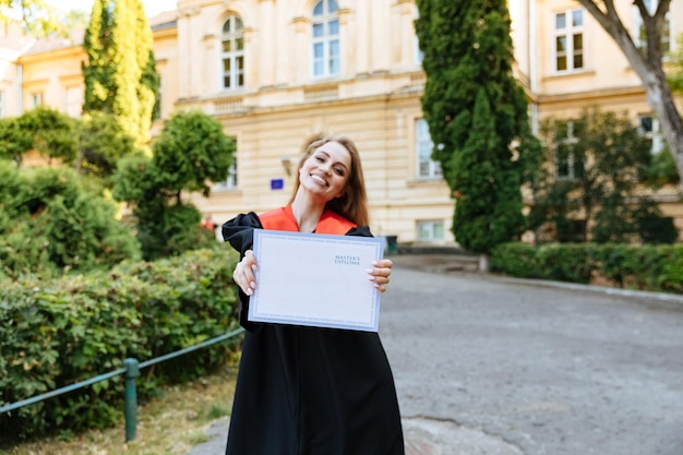 A happy student receiving a diploma, symbolizing the successful use of 529 plan funds for education. The background shows a university campus.