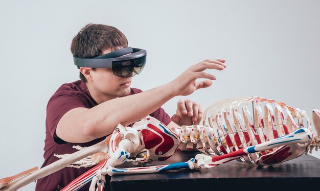High school students are using VR headsets to explore the human anatomy in a biology class. The VR experience allows them to visualize complex structures and processes in a more intuitive and engaging way. The teacher is guiding them through the virtual environment, answering questions and providing additional explanations.