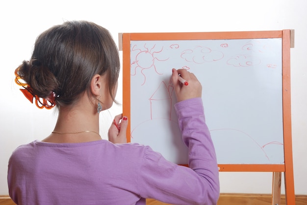 A student solving a complex math problem on a whiteboard, using different colored markers to illustrate the steps. They are surrounded by math textbooks and notes, with a calculator on the table. The focus is on the problem-solving process and the student's focused expression.