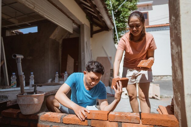 A student smiles as she helps build a house with other volunteers during her gap year community service project.