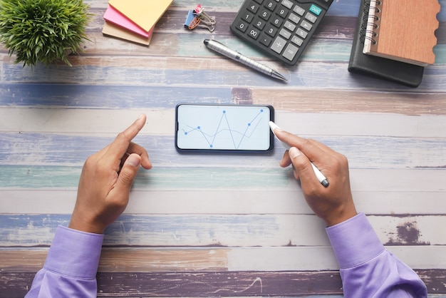 A person using a budgeting app on their smartphone, showing expense tracking and financial goal setting.