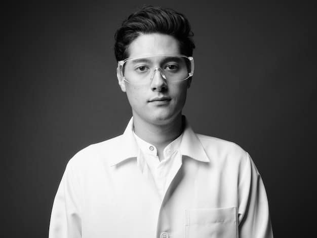 A black and white professional headshot of a young K-Drama actor. He has a serious expression on his face and is wearing a stylish outfit. The lighting is dramatic, highlighting his features.