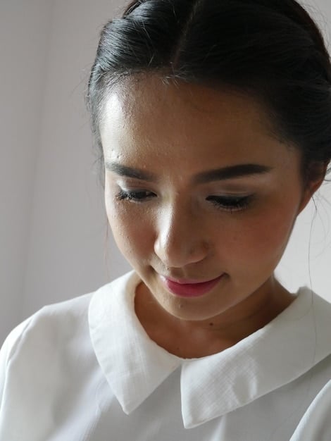 A close-up photograph of Kim Hee-ae, capturing her elegant poise and subtle emotional expression. She is dressed in a sophisticated outfit, and the lighting highlights her graceful features and captivating gaze.