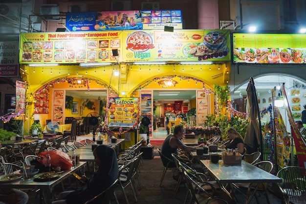A panoramic view of a bustling street food market in Seoul, with vibrant stalls offering a wide variety of traditional Korean snacks and dishes. People are shown enjoying the food, creating a lively and immersive cultural experience.