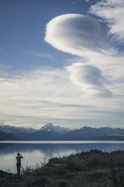 A screenshot of Adobe Camera Raw interface, highlighting controls for exposure, contrast, white balance, and other adjustments. The image being edited is a high-contrast landscape with a dramatic sky.