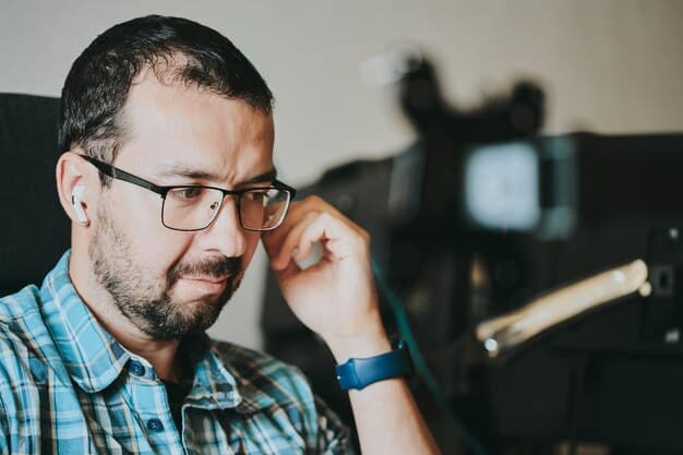 Close-up of a casting director reviewing audition tapes on a laptop, with a thoughtful expression. The screen shows a grid of actresses, each performing their audition piece. A stack of headshots sits beside the laptop.